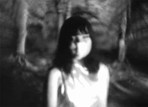 a black and white photo of a woman with a blurred background