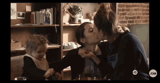 a woman kissing another woman with a 10 on the bottom