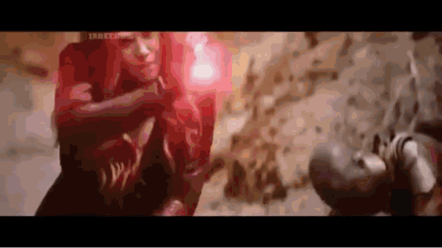 scarlet witch is holding a red glowing object in her hand while fighting captain america .
