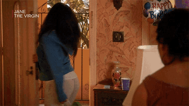 a woman standing in front of a door that says jane the virgin on it