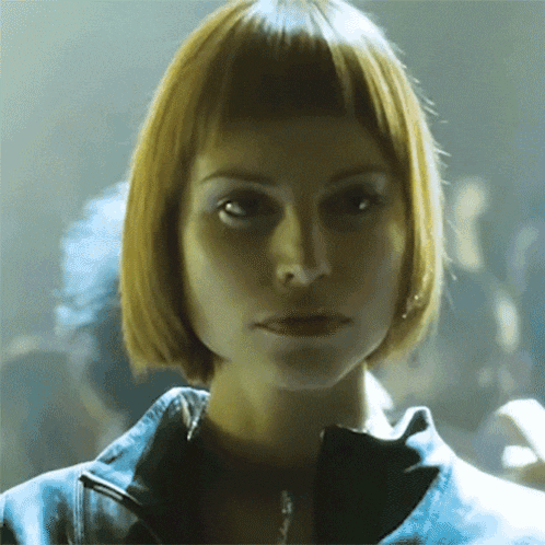 a woman with short blonde hair looks at the camera