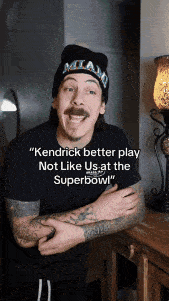 a man wearing a hat says kendrick better play not like us at the super bowl