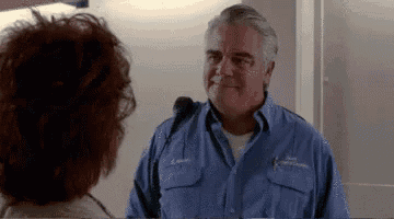 a man in a blue uniform is talking to a woman with red hair .