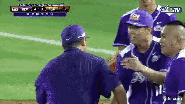 a group of baseball players are shaking hands with a man wearing a purple hat that says tips