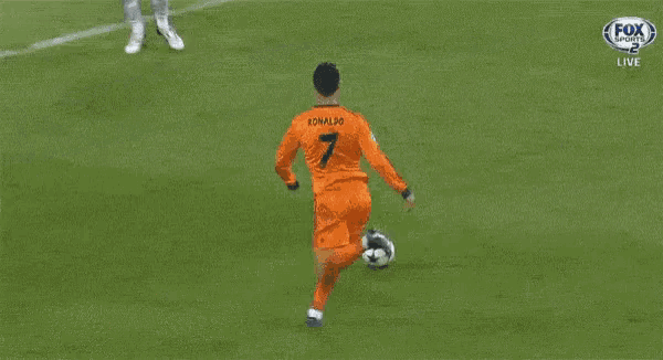 a soccer goalie catches a ball in front of a heineken advertisement