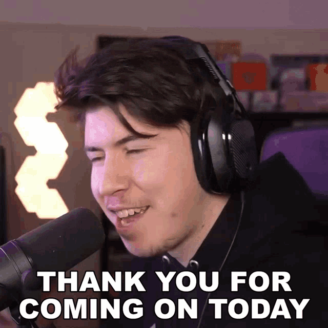 a man wearing headphones says " thank you for coming on today " in front of a microphone