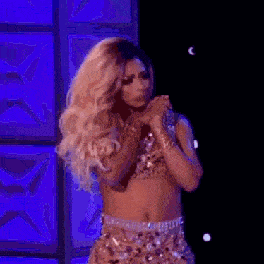 a woman in a crop top and skirt is singing into a microphone .