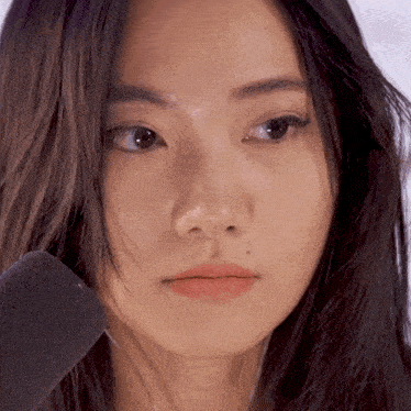 a close up of a woman 's face with a microphone in front of it