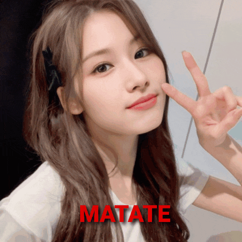 a woman giving a peace sign with the word matate in red behind her