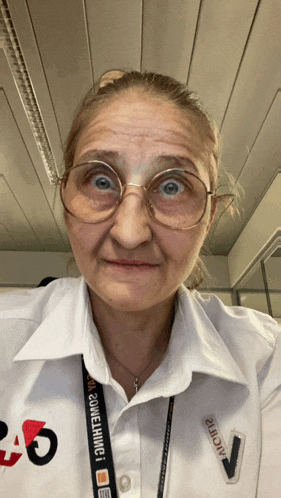 a woman wearing glasses and a white shirt with the number 26 on the front