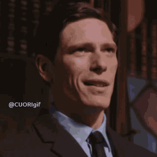 a man in a suit and tie is smiling with the hashtag @cuorigif