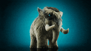 a stuffed mammoth with a blue eye is standing on a blue surface