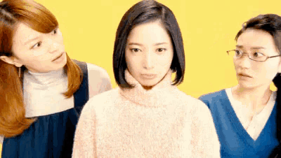 a woman in a pink sweater is standing between two other women