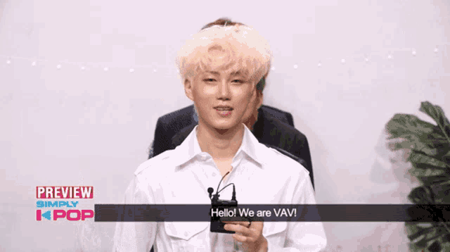 a man holding a microphone says hello we are vav!