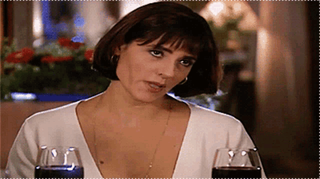 a woman is holding two glasses of wine in her hand