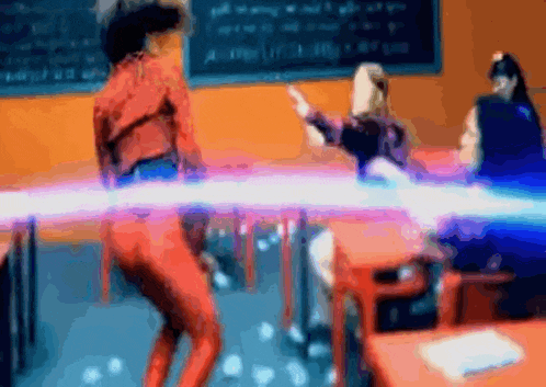 a blurry picture of people dancing in a classroom with a chalkboard in the background