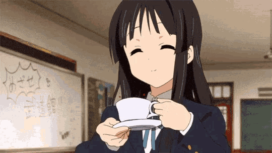 a girl in a school uniform is holding a cup of coffee in her hand .