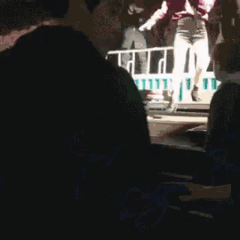 a blurry picture of a man standing in front of a crowd .