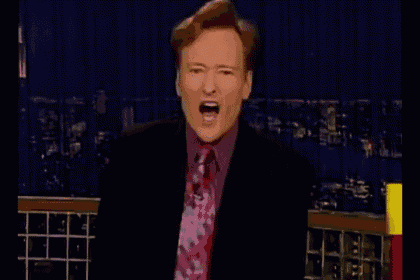 a man in a suit and tie is yawning with his mouth open