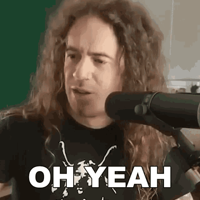a man with long curly hair is talking into a microphone and the words oh yeah are above him