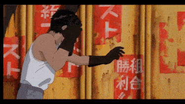 a man in a white tank top is standing in front of a yellow wall with chinese writing on it