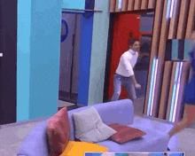 a man and a woman are dancing in a room with a couch .
