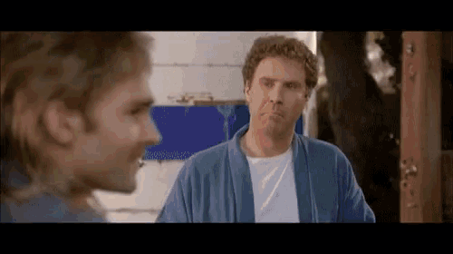 a man in a blue robe is looking at another man in a white shirt .