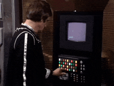a man pressing a button on a machine with a screen that says ' i 'm sorry ' on it