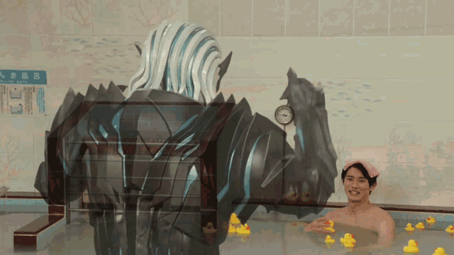 a man is taking a bath in a bathtub with rubber ducks and a robot in the background