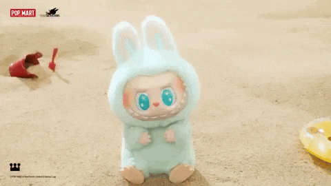 a stuffed animal in a bunny costume is sitting on a sandy beach .
