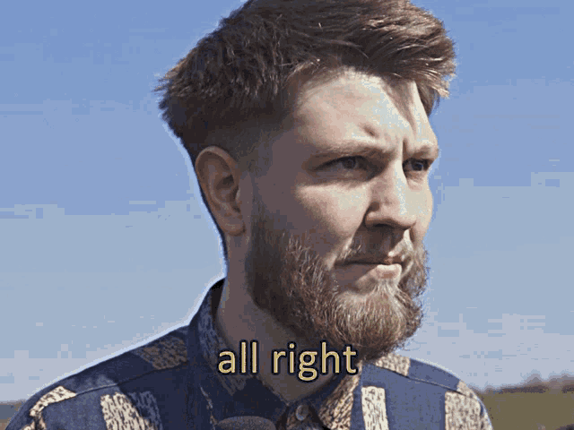 a man with a beard and a shirt that says all right on it