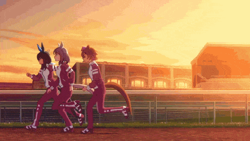 a group of people running on a track at sunset