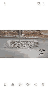 a drill is cutting through a pile of rocks in a concrete area .