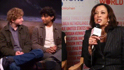 a woman is speaking into a microphone in front of a sign that says world women