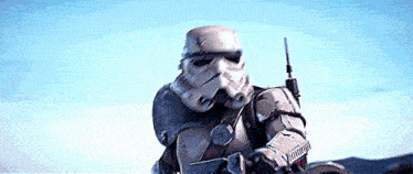 a storm trooper from star wars is riding a bike in the desert .
