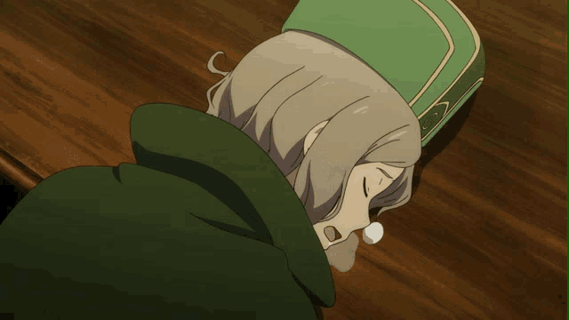 a person laying on a table with a green hat on