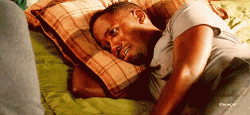 a man is laying on a bed with a pillow .