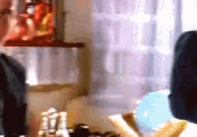 a woman is looking at herself in a mirror while sitting at a table .