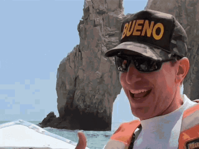 a man wearing sunglasses and a hat that says bueno