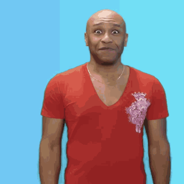 a bald man wearing a red shirt is making a surprised face