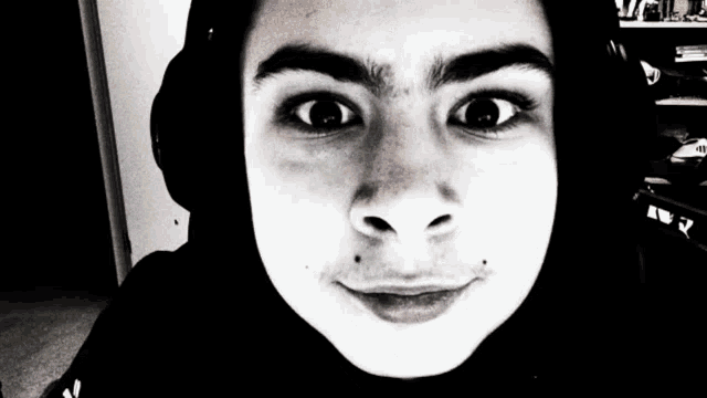 a black and white photo of a person wearing headphones and a black hoodie