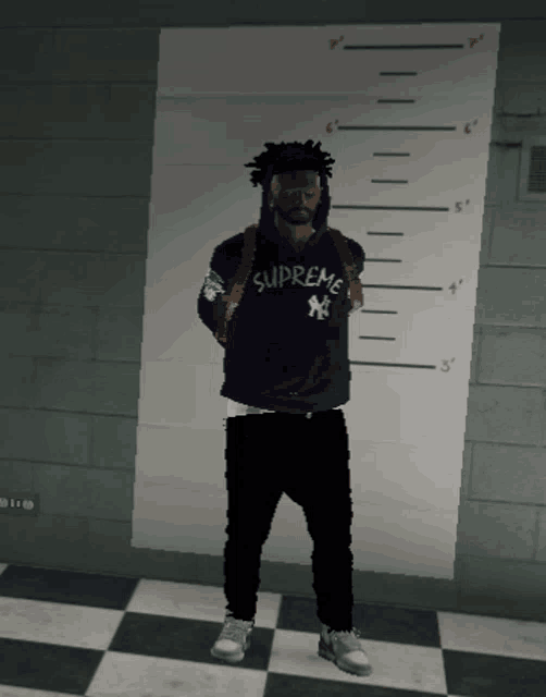 a man wearing a supreme hoodie is standing in front of a wall