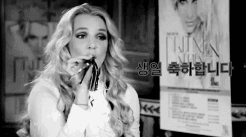 a black and white photo of a woman holding a cigarette in her mouth .