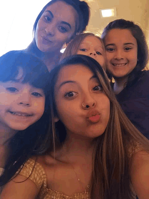 a group of girls posing for a picture with one of them wearing a nose ring