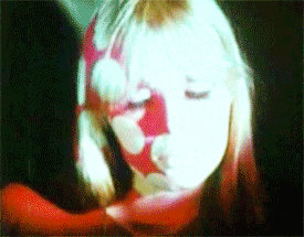 a close up of a woman 's face with a red and white floral pattern on it