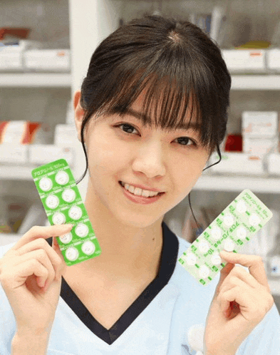 a woman is holding two packs of pills one of which has a label that says 400mg on it