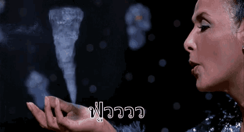 a woman blowing smoke out of her hand with a foreign language written on the bottom