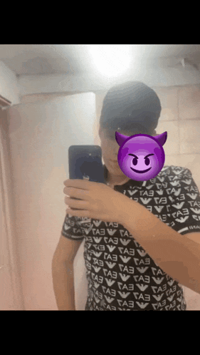 a man taking a picture of himself with a devil face on his face