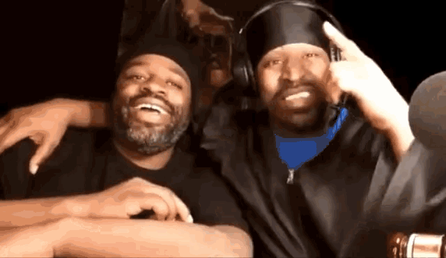 two men wearing headphones are posing for a picture together
