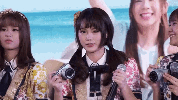 a group of young women are holding cameras and microphones in their hands .